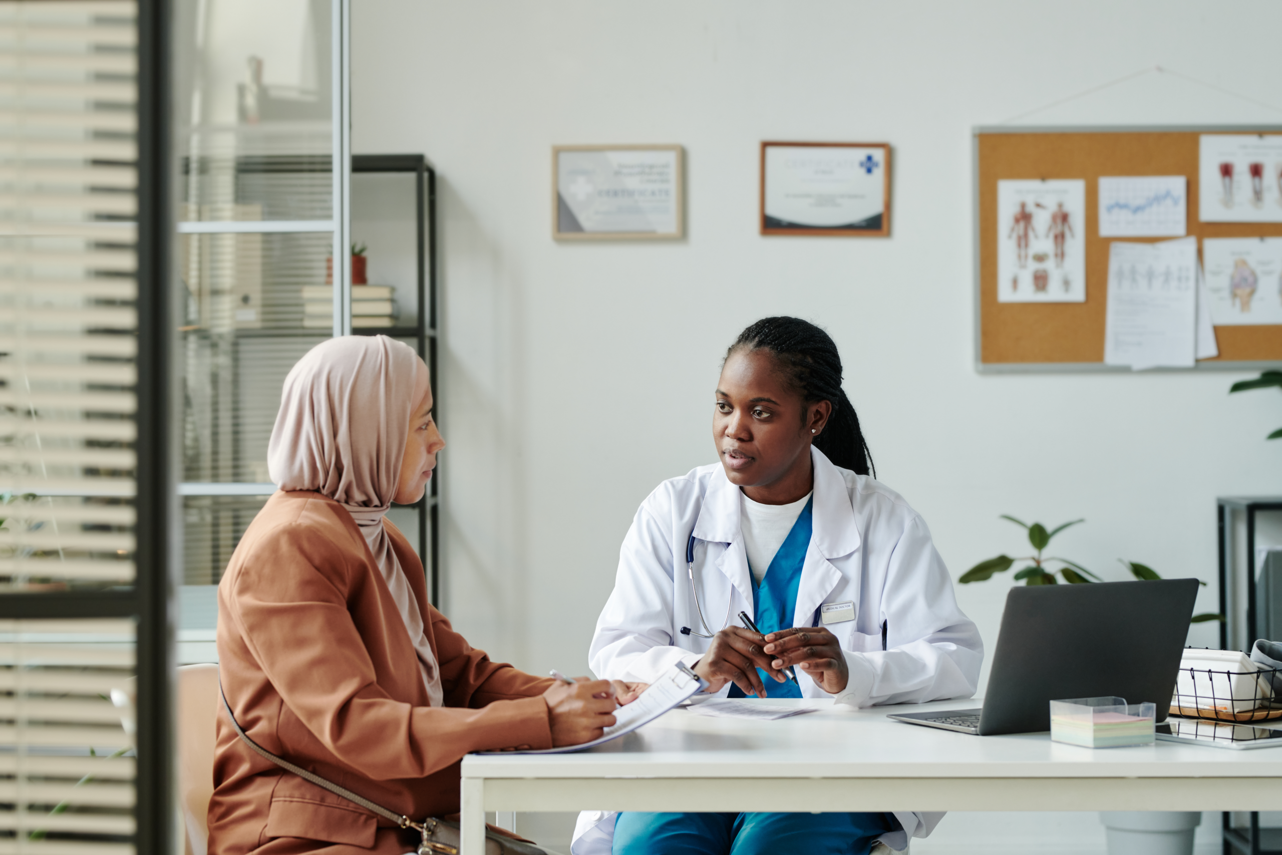 Doctor sits with patient that has chest pain.